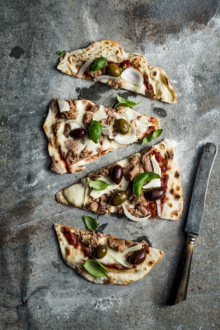 Flatbread pizza with tuna, olives, onion, basil and mozzarella