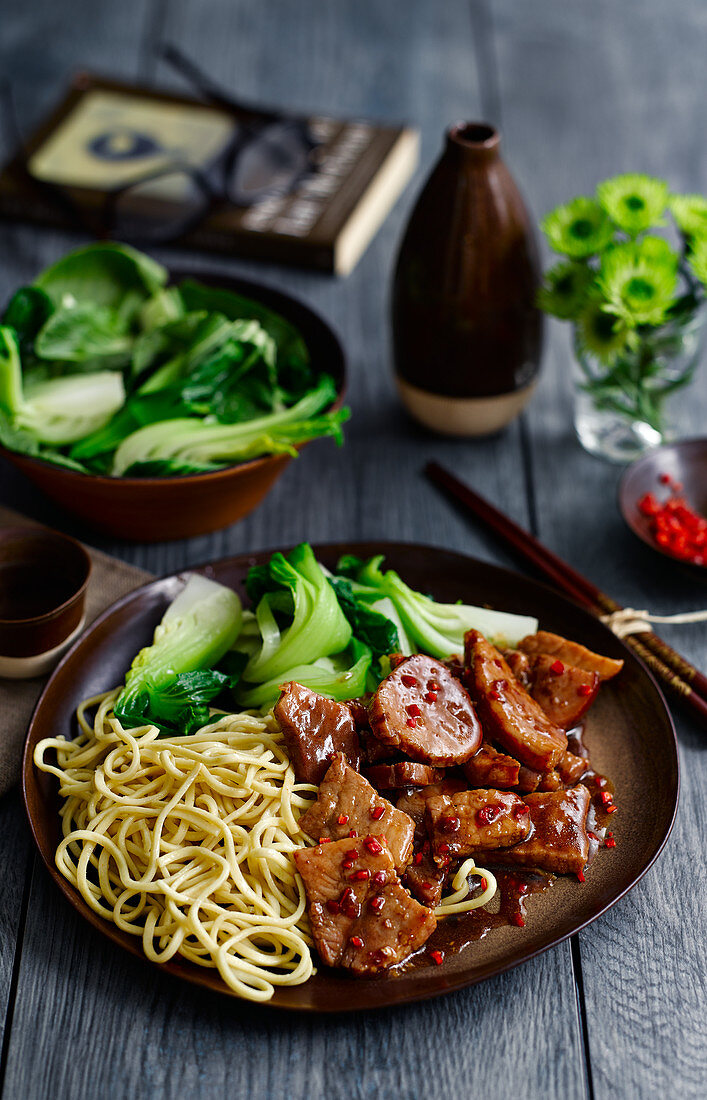 Szechuan style pork with noodles and pak choi