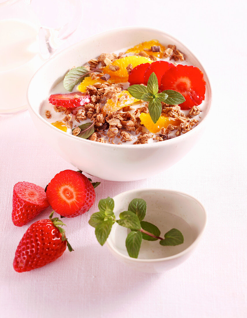A bowl of crunchy chocolate muesli with fruit and milk