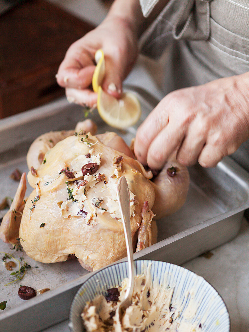 Woman preparing chicken for roast, close-up