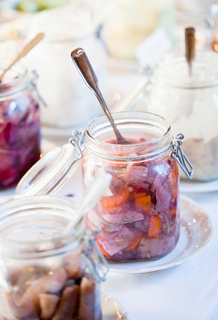 Herring salad with carrots in glass jars at a buffet