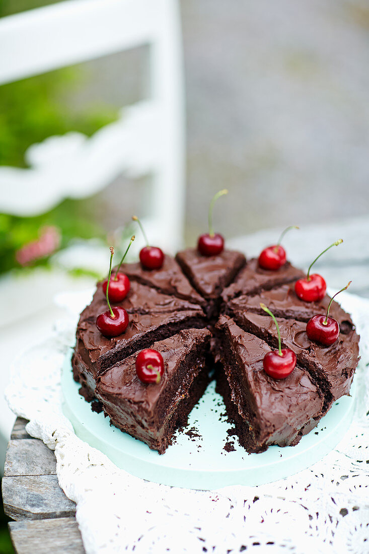 Schokoladenkuchen mit Kirschen auf Holztisch