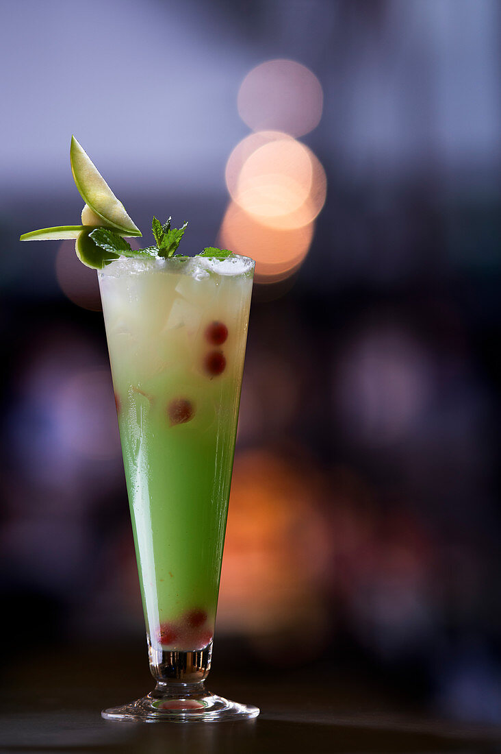 Grüner Cocktail mit schwarzen Johannisbeeren
