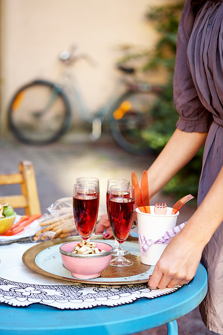 Frau serviert Drinks auf Tablett