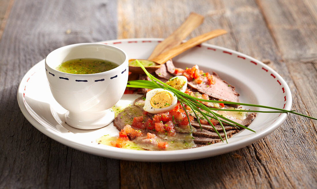 Cold sliced roast beef with potato vinaigrette, quail egg and tomato