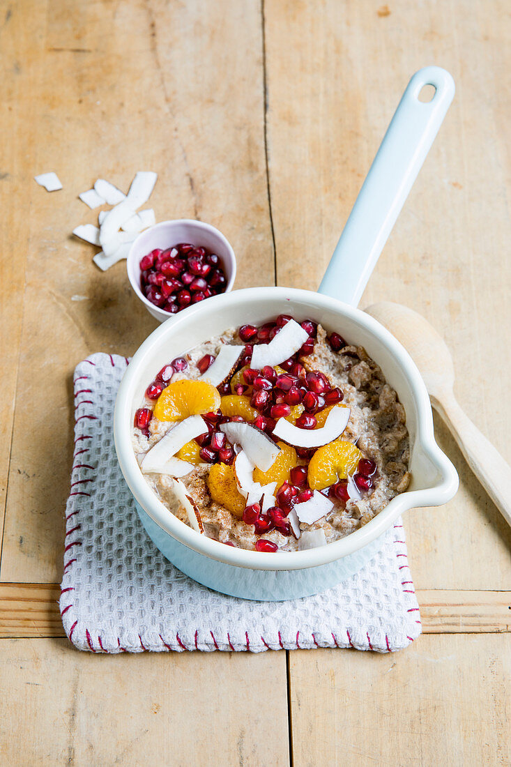 Coconut and clementine porridge with flax seeds and pomegranate seeds