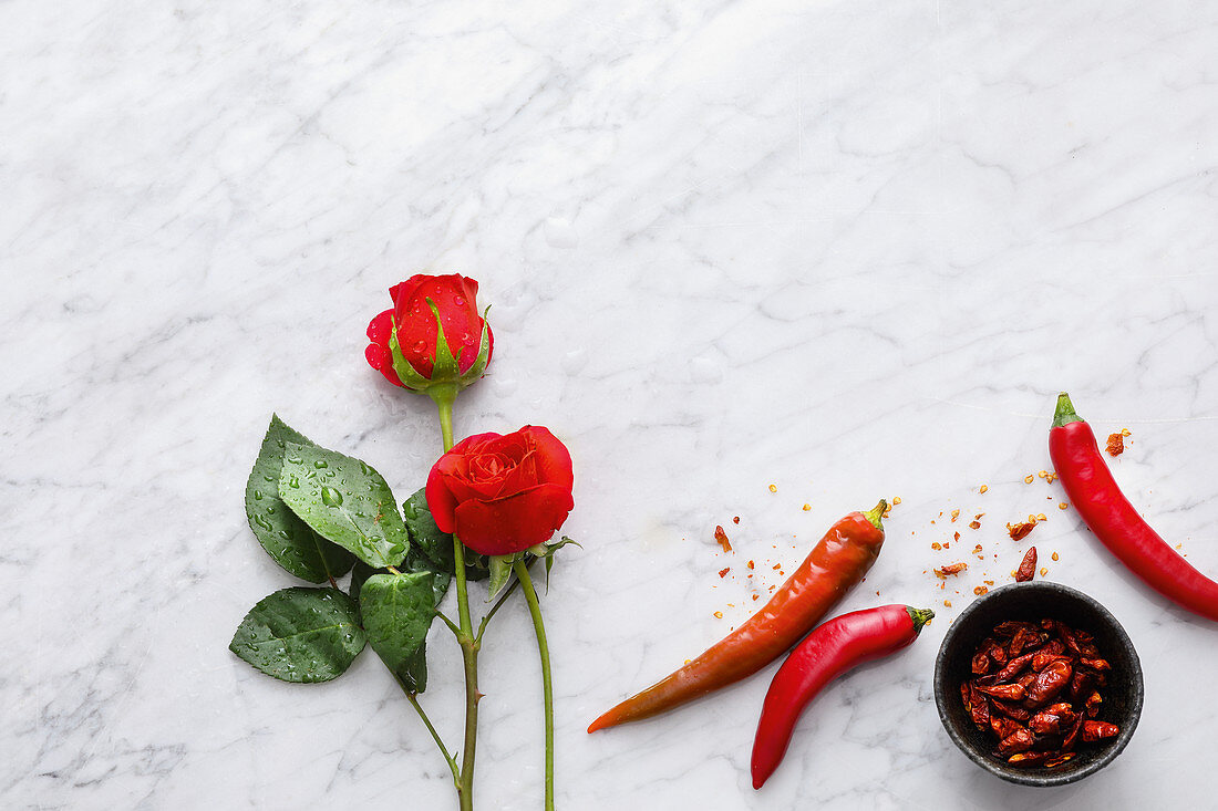 A symbolic image for spicy romantic meals: roses and chilli