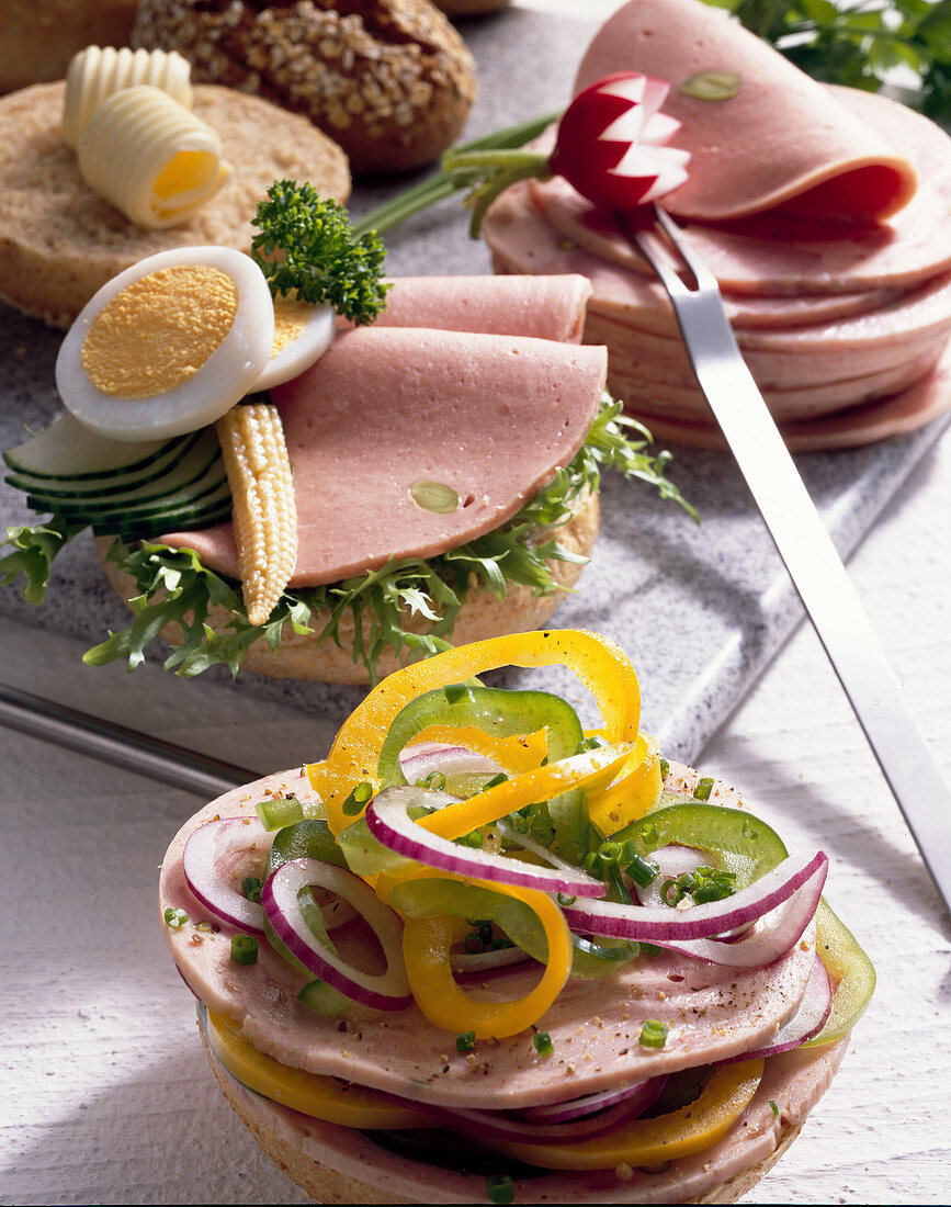 Sausage sandwiches with cucumber, onion rings and peppers, or with cucumber, egg and sweetcorn