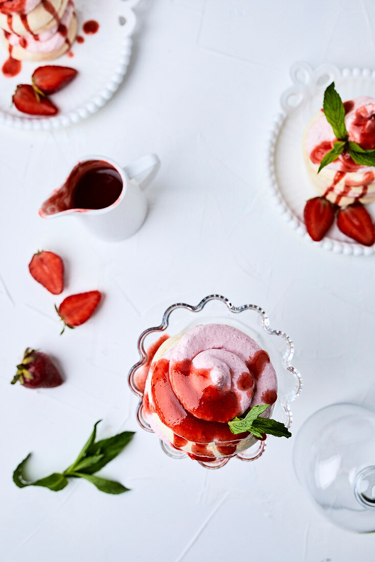 Kleine Erdbeer-Pavlovas, mit Erdbeersauce übergossen