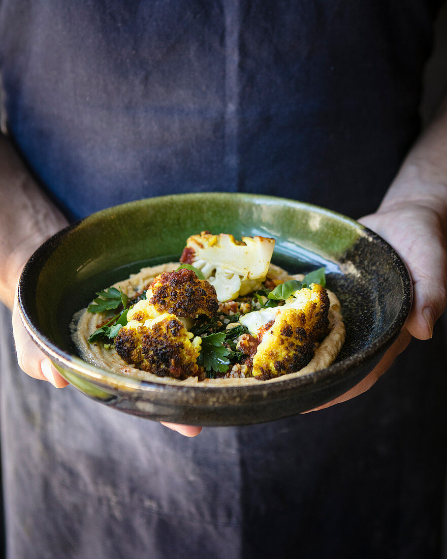 Ras el hanout-baked cauliflower with bulgur wheat, red quinoa and kale salad, and cauliflower hummus