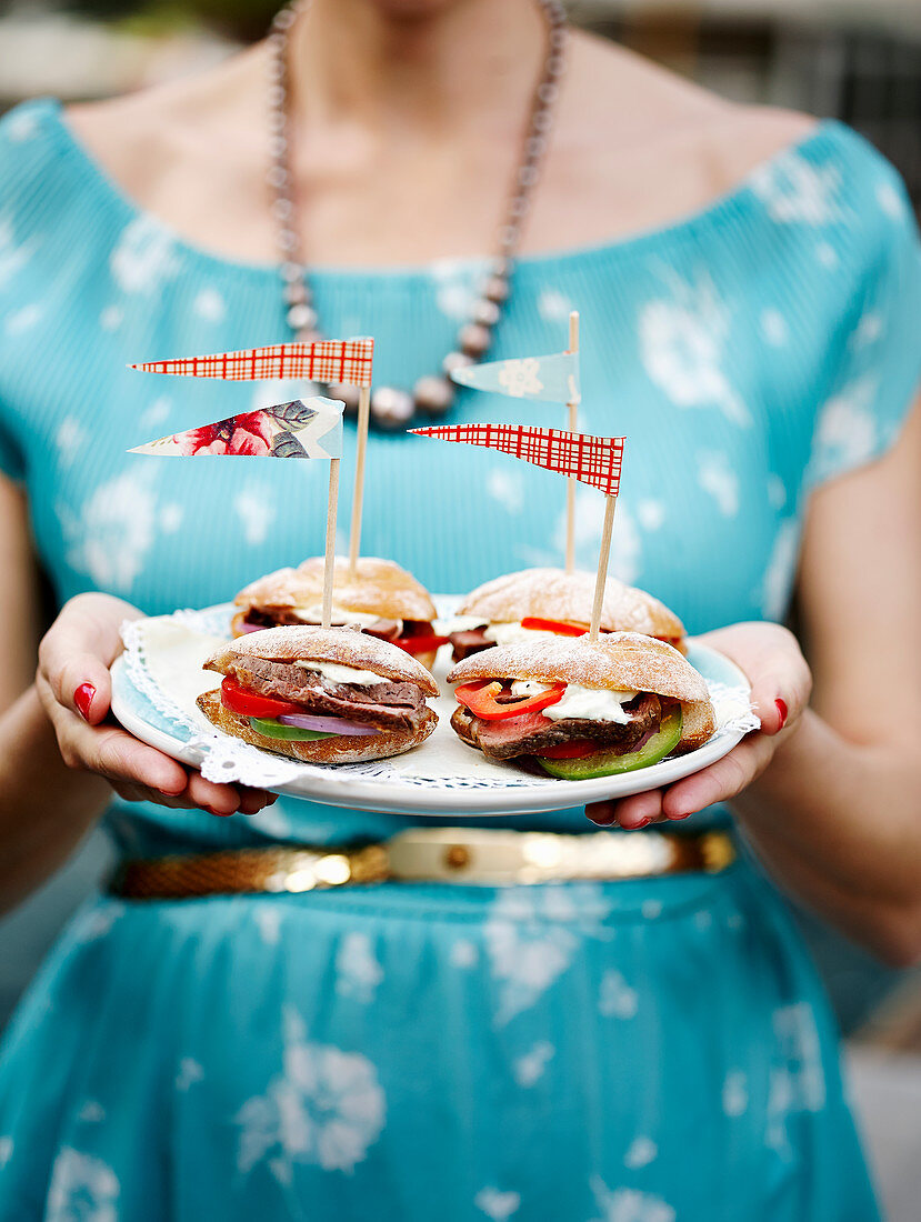 Frau hält Teller mit Sandwiches