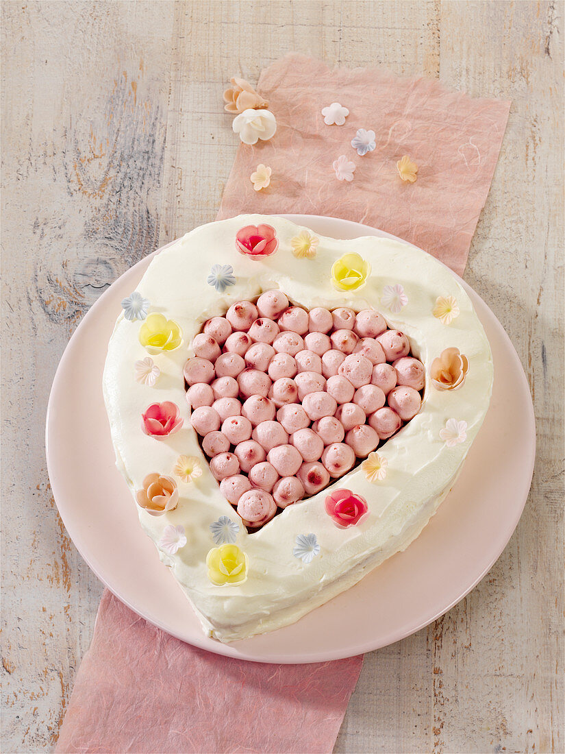 A heart-shaped cream cheese cake with raspberries