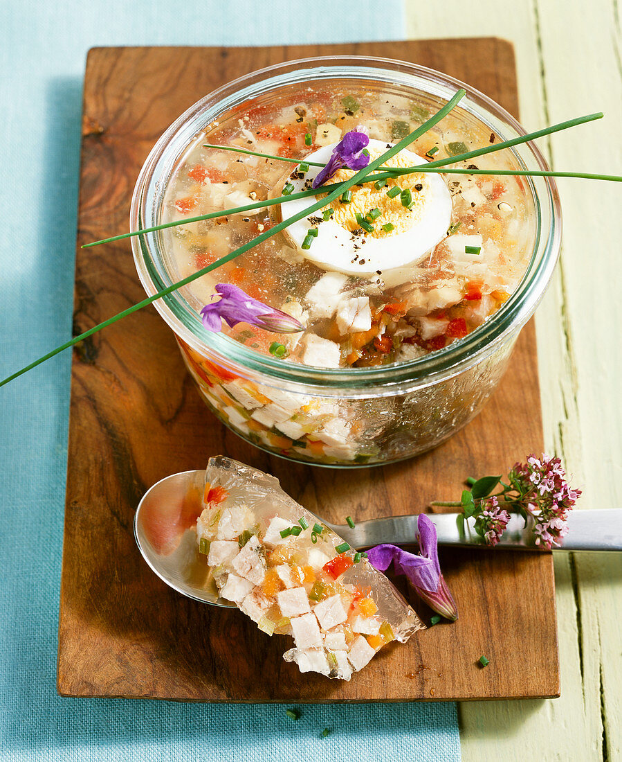 Roast pork brawn in a mason jar with boiled eggs, chives and flowers