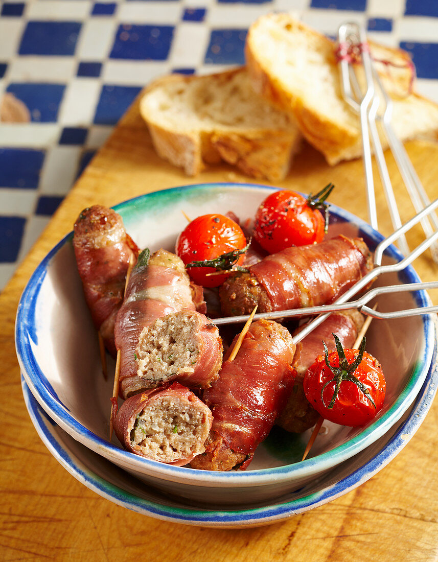 Minced meat and sage rolls with serrano ham, sherry tomatoes and white bread (Spain)