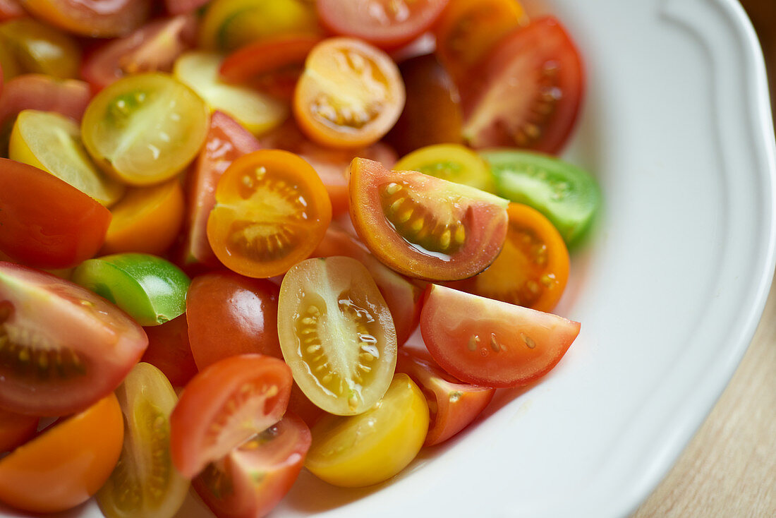 Colourful tomatoes, halved and quartered, on a plate