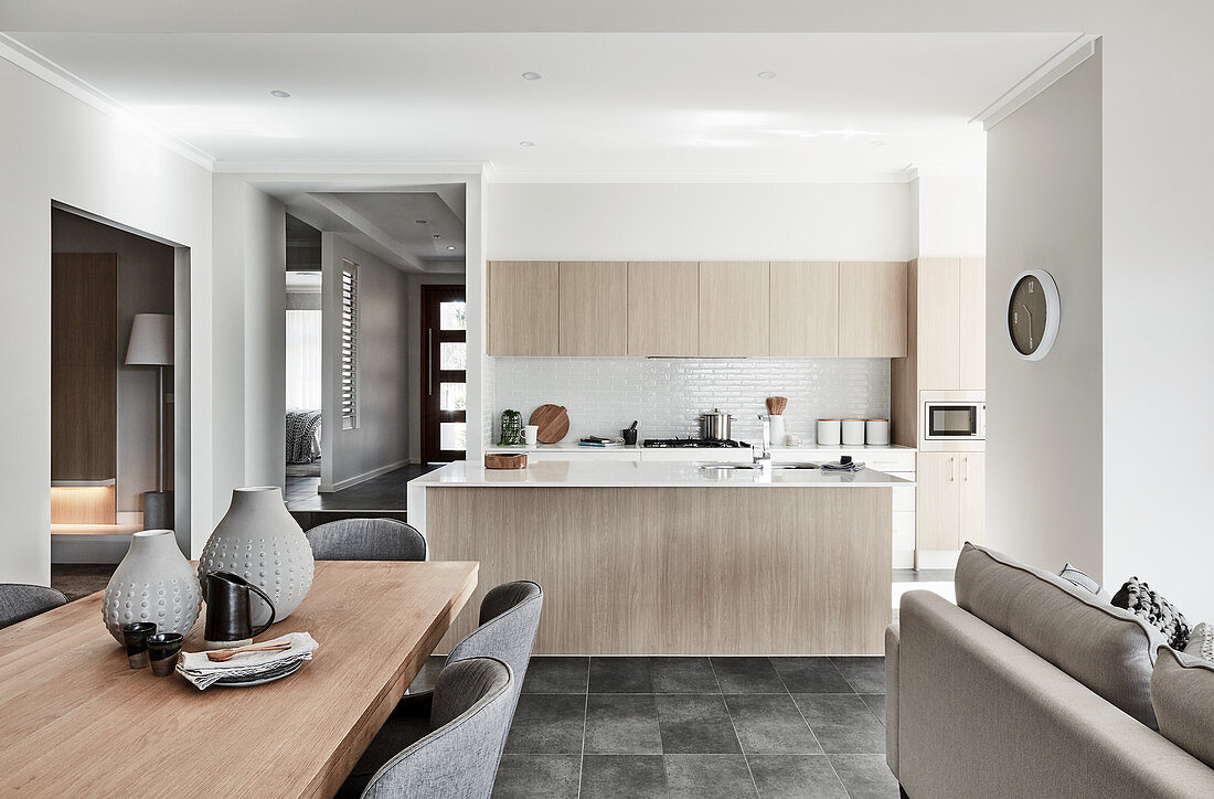 Dining area, sofa and kitchen in open-plan interior