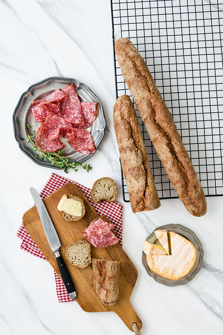 Baguette mit Sonnenblumenkernen serviert mit Käse und Salami