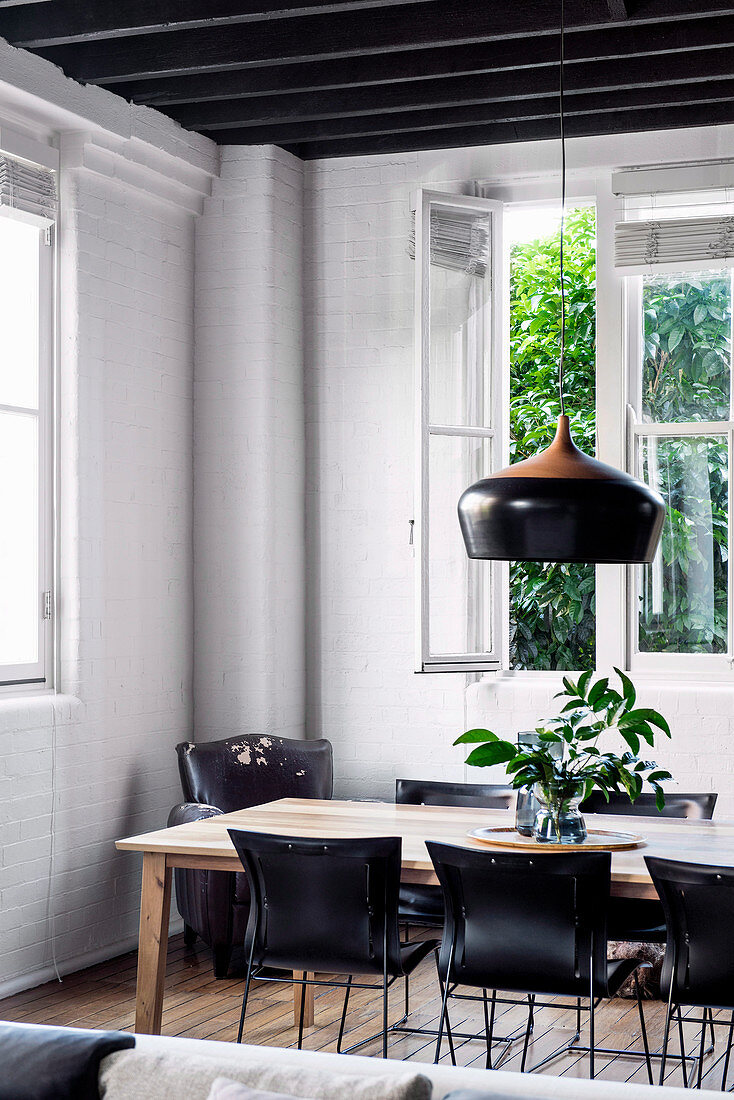 Black chairs at the dining table in an old building with white brick walls