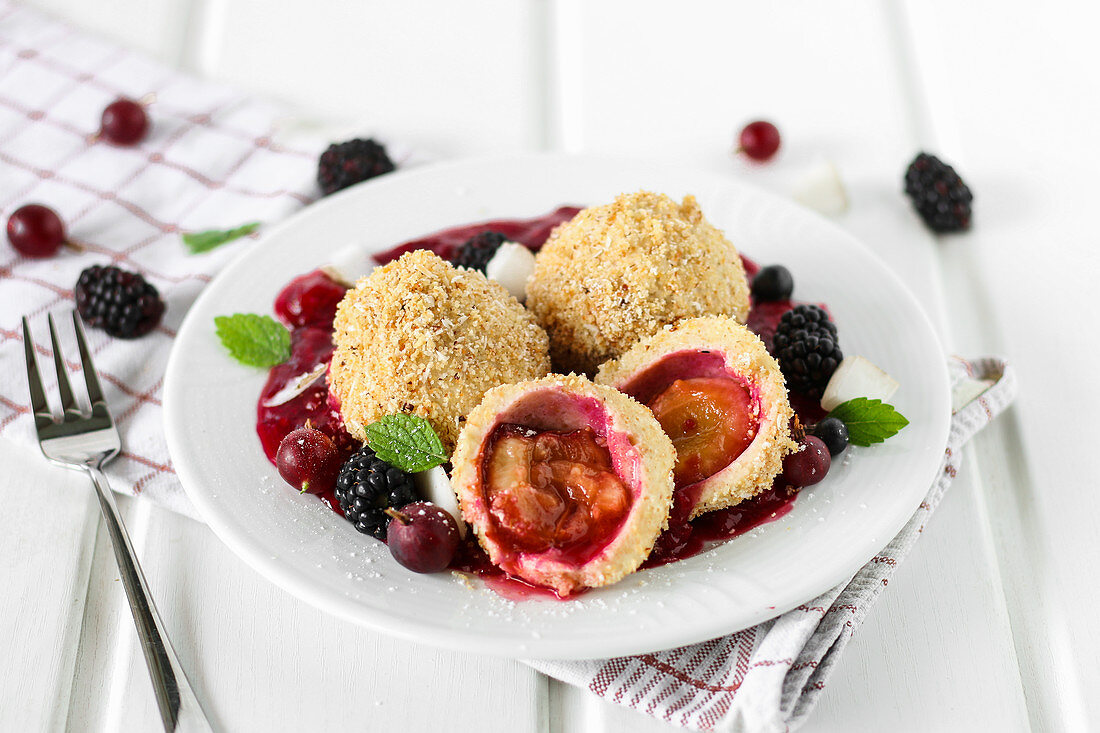 Zwetschkenknödel auf Beerenspiegel