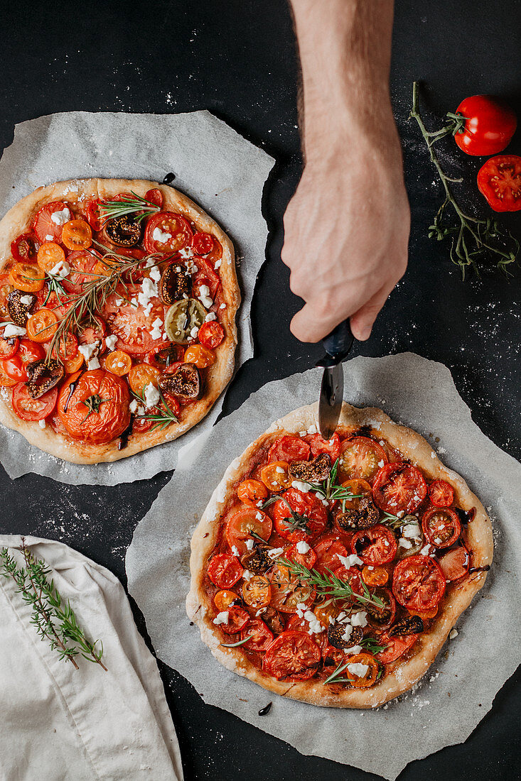 A homemade pizza with figs and tomatoes