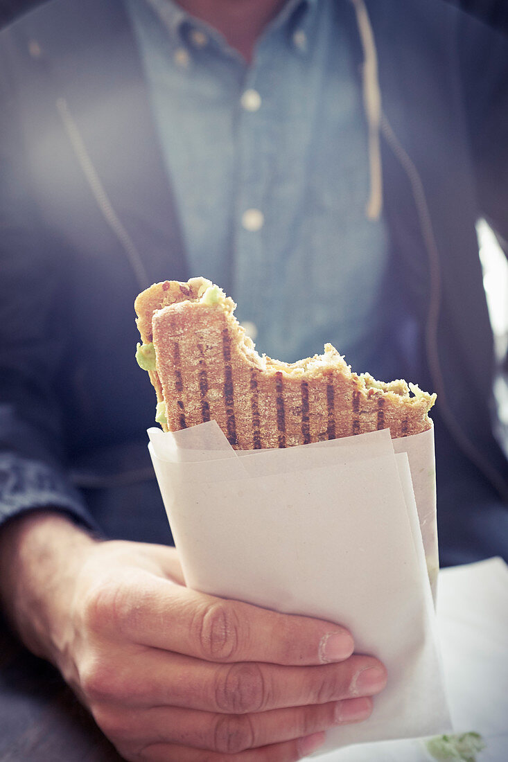 Hand hält Panini-Sandwich