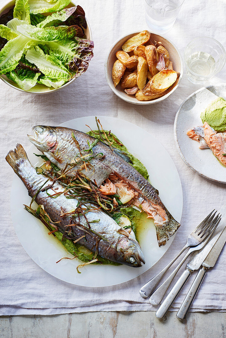 Trout with lovage, pea purée and crisp spring onions