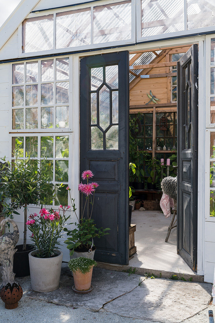 Open double doors leading into idyllic summerhouse made from old windows