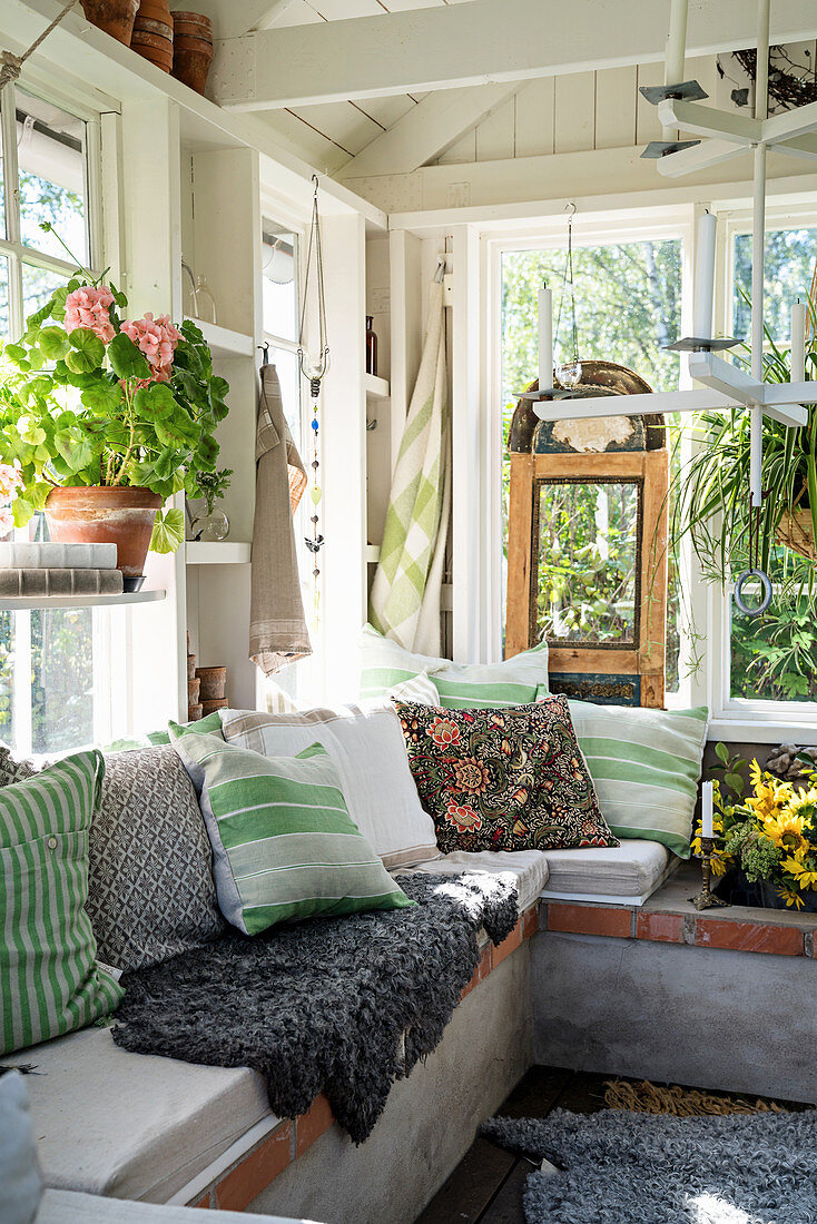 U-shaped masonry bench in summery conservatory