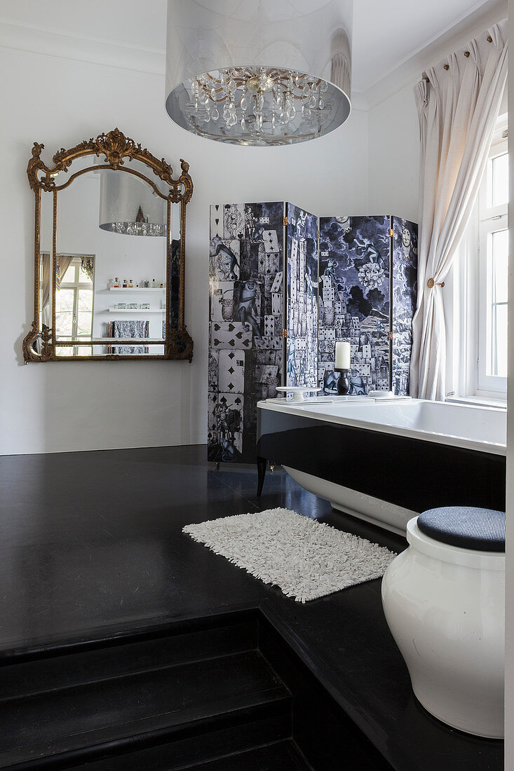 Baroque mirror in bathroom with steps leading to free-standing bathtub