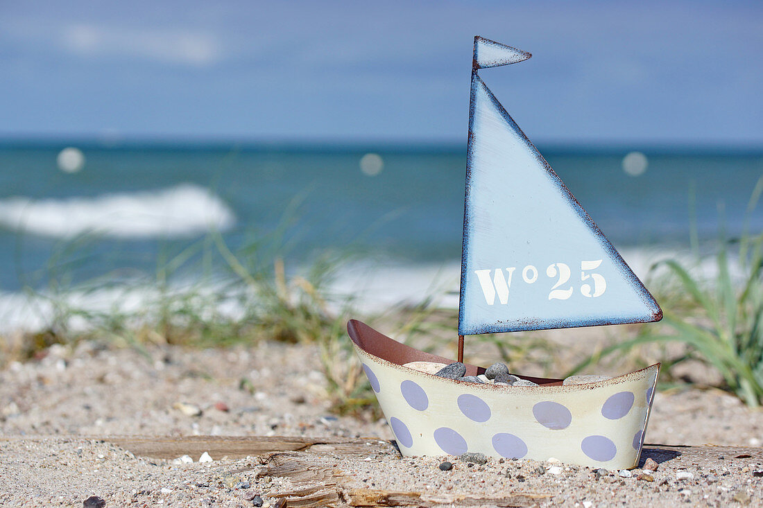 Small toy sailing boat on beach