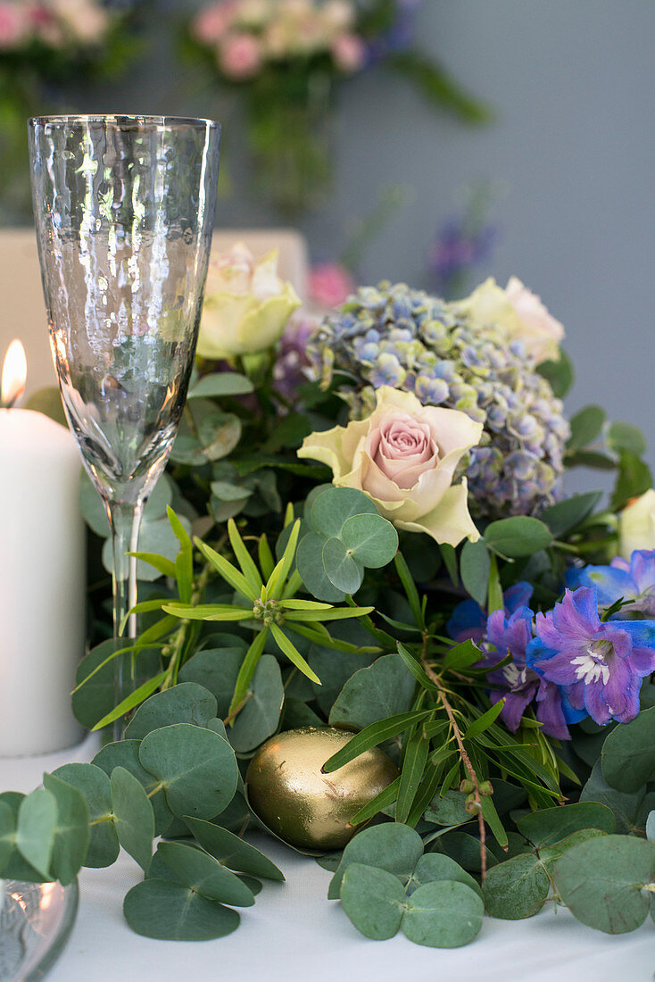 Festively decorated table with lavish floral garland as centrepiece