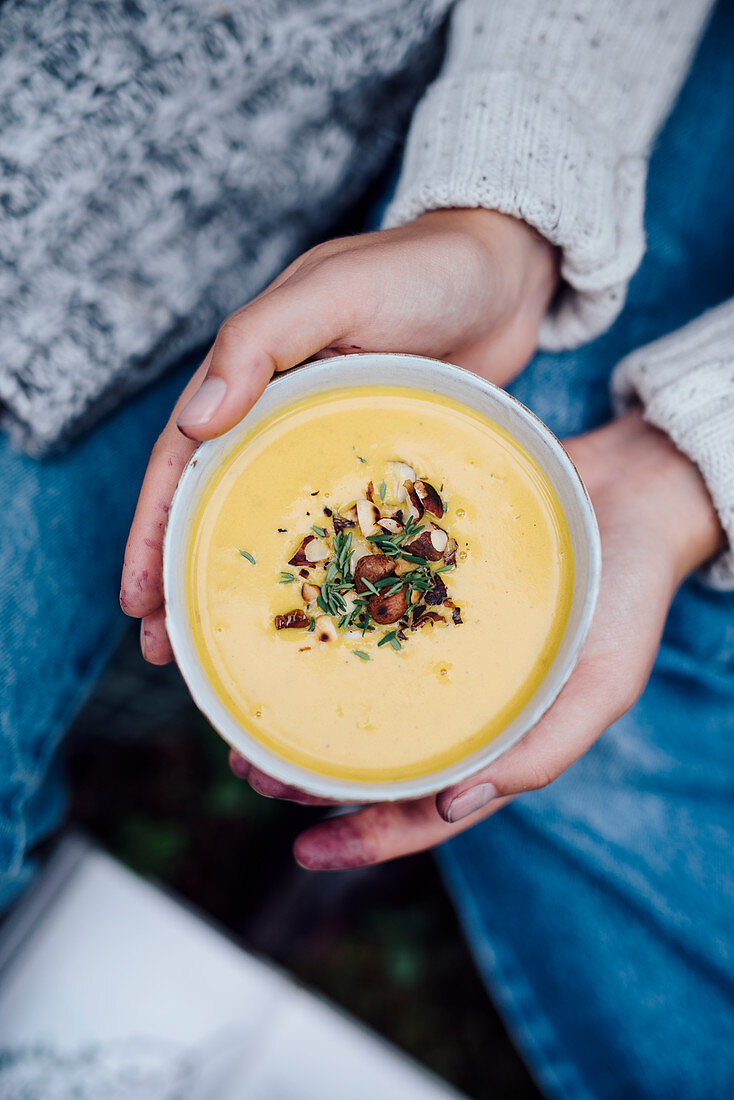 Woman holding a bowl with soup