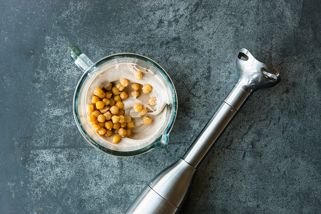 Kichererbsen mit Zitronensaft zu Hummus pürieren