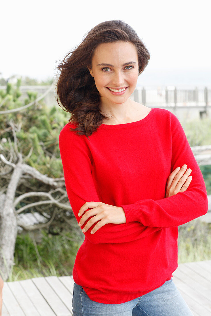 A young brunette woman wearing a red jumper