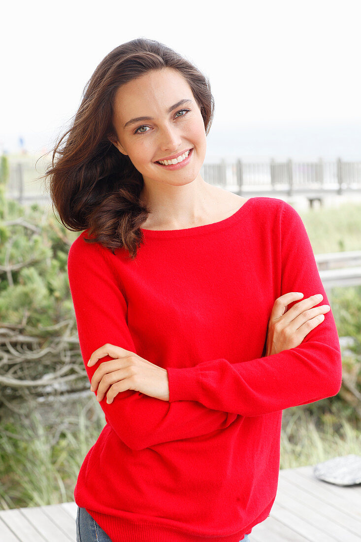 A young brunette woman wearing a red jumper