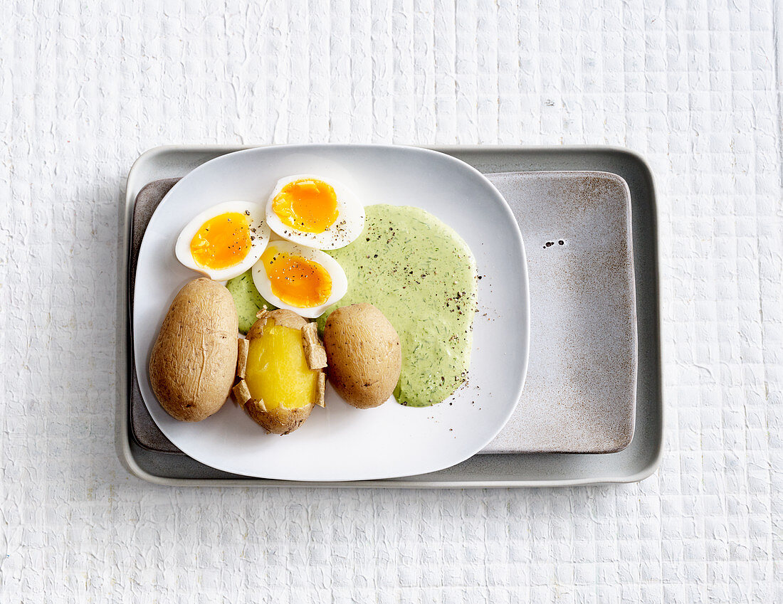 Soft-boiled eggs with green sauce and potatoes
