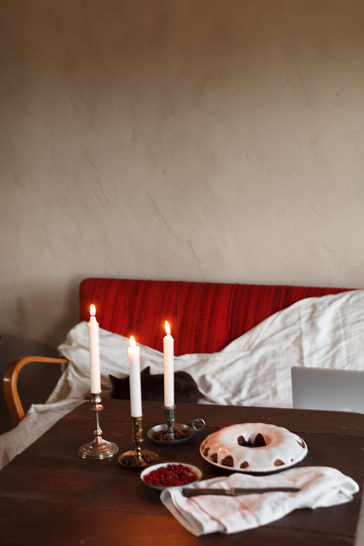 Napfkuchen mit Zuckerglasur auf Holztisch mit Kerzen
