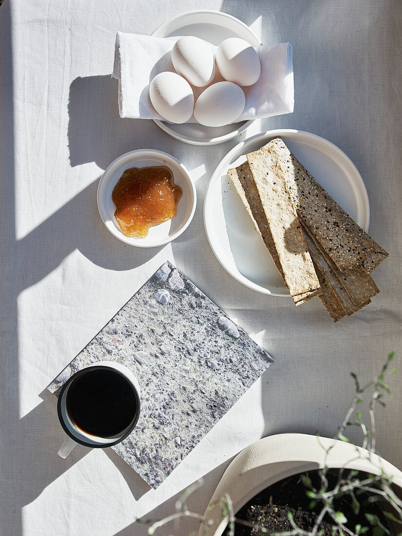 Frühstück mit Kaffee, Marmelade, Ei und Knäckebrot