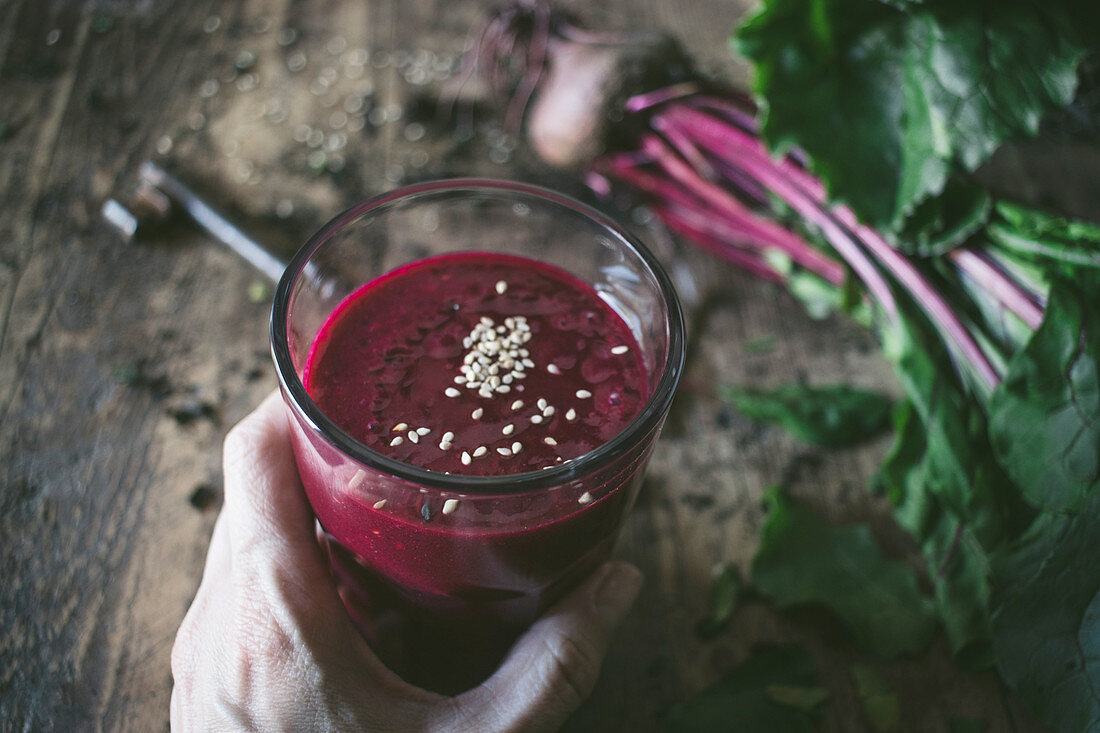 Hand holding beetroot smoothie