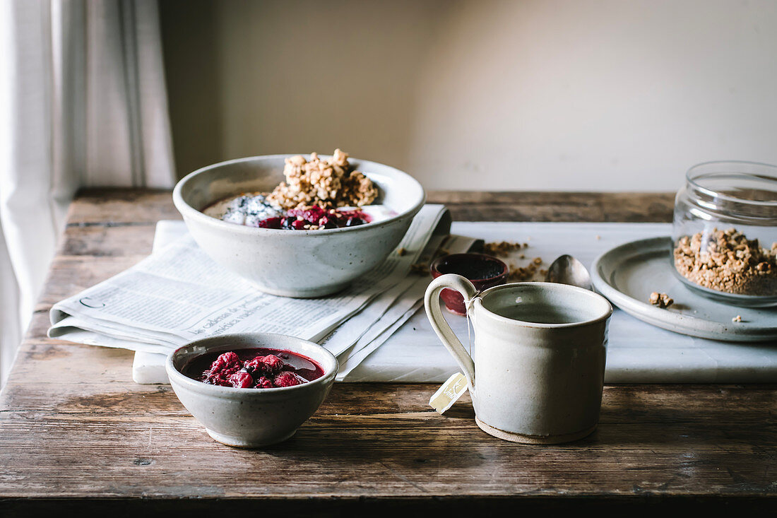 Breakfast Bowl mit Reis, Quinoa, Granola und Beeren auf Frühstückstisch