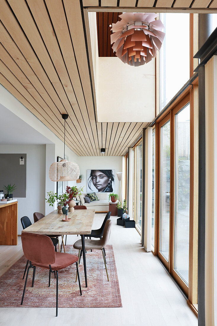 Dining table and chairs next to glass wall in open-plan interior