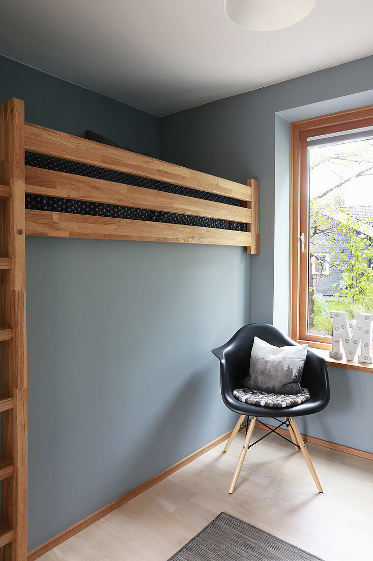 Stockbett in hellgrauem Kinderzimmer, Klassikerstuhl vor Fenster