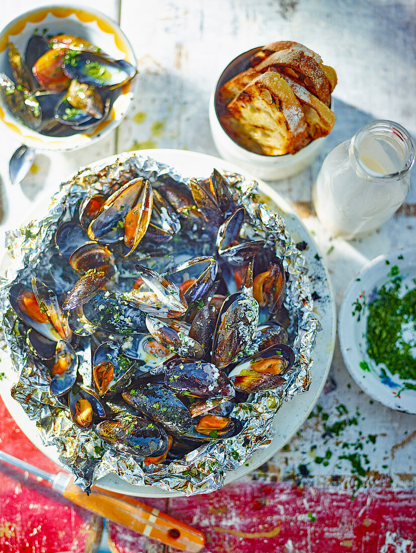 Grilled mussels with parsley in foil