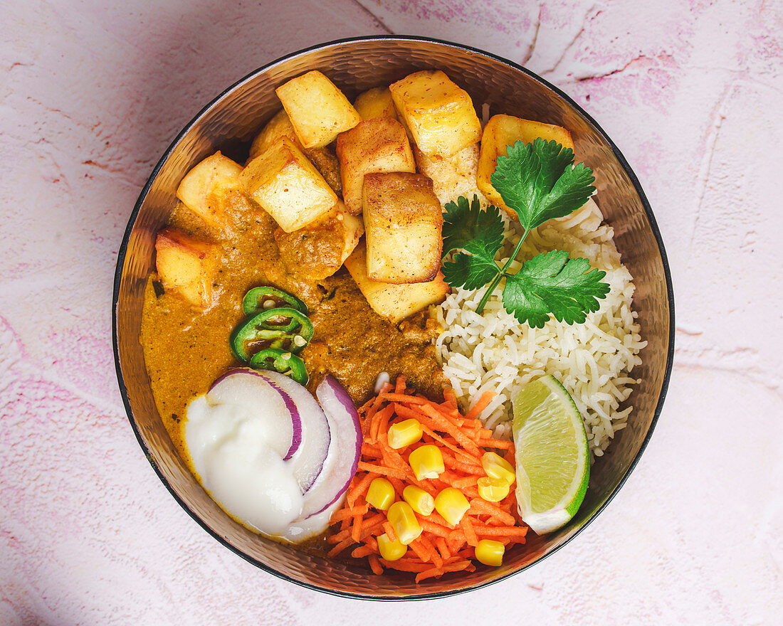 Indian tofu and potato curry with rice, vegetables and yogurt