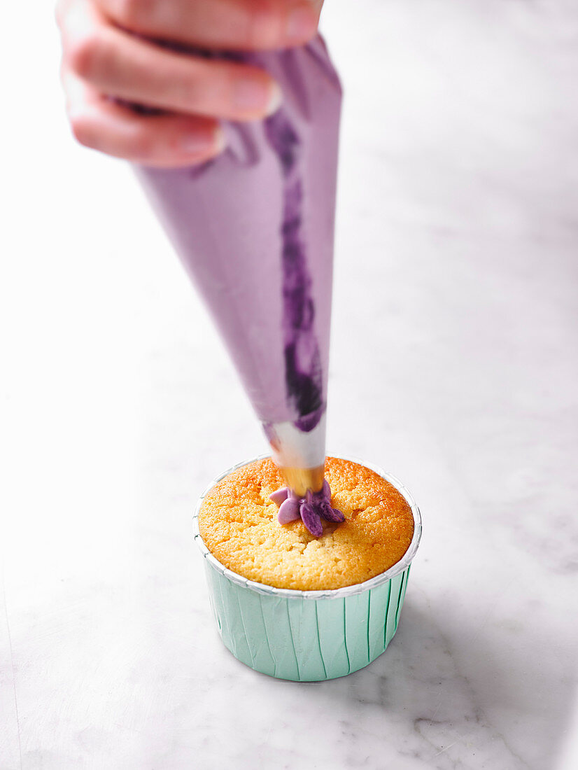 Decorating a cupcake with a buttercream flower