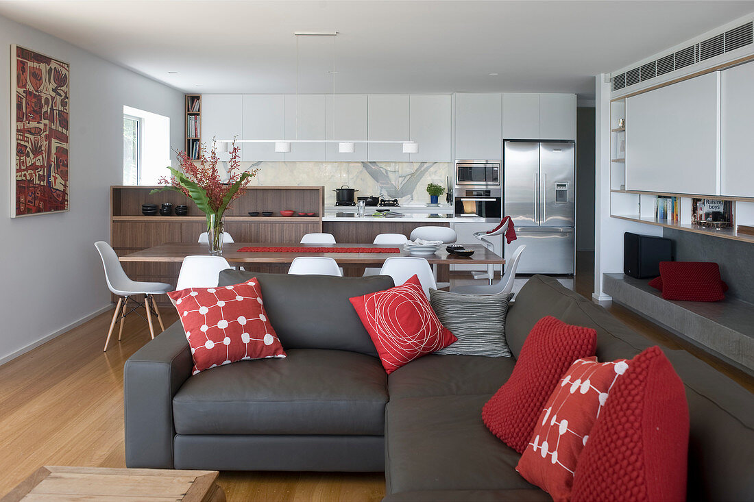 Sofa set with red scatter cushions in elegant, open-plan interior