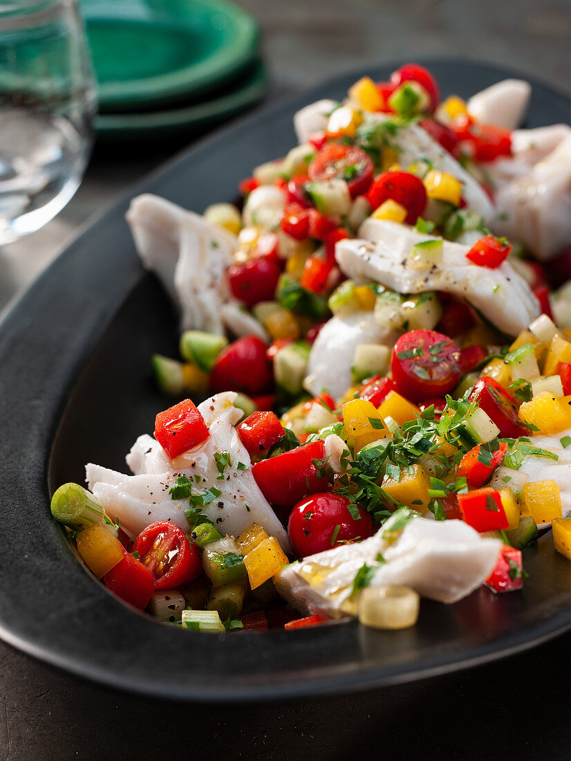 Carpaccio fish salad with cherry tomatoes and peppers