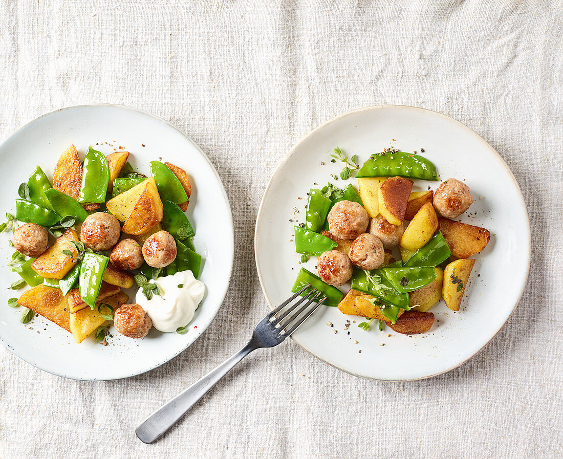 Fried potatoes and sausages with mange tout