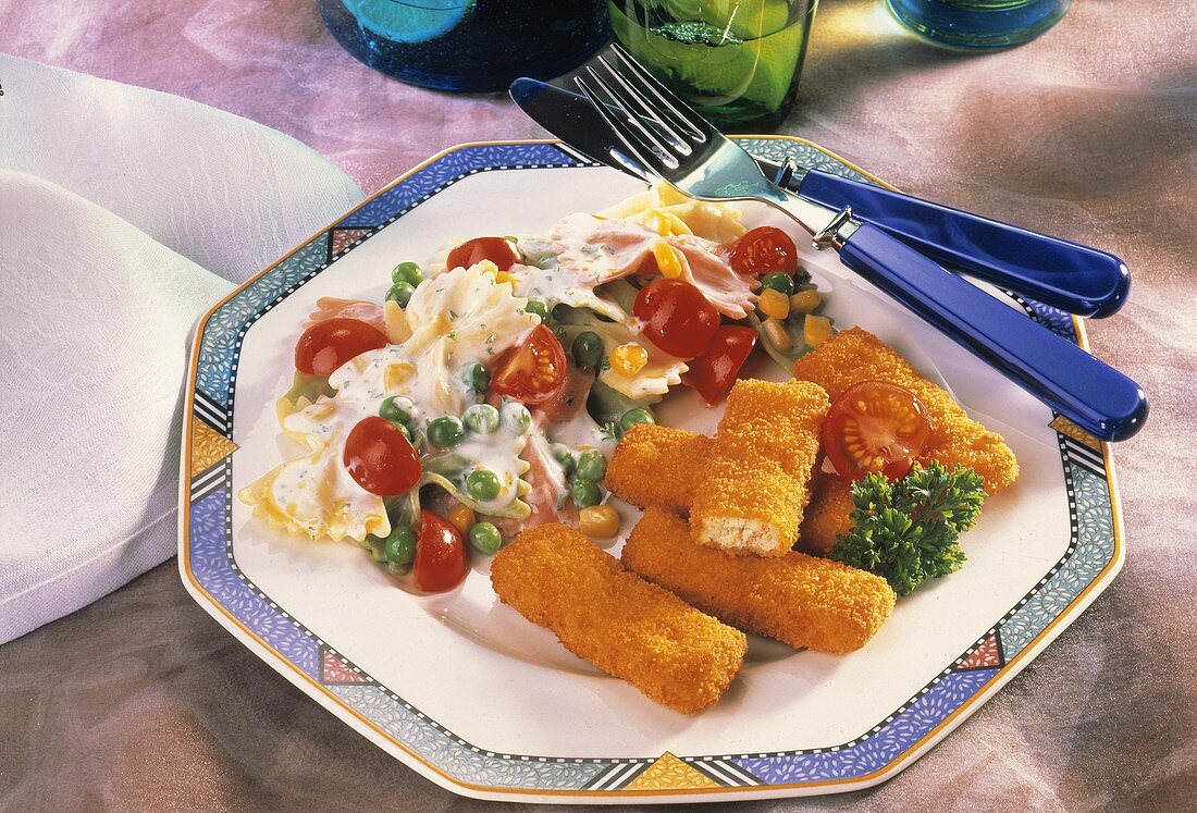 Geflügelstäbchen mit buntem Nudel-Gemüse-Salat auf Teller