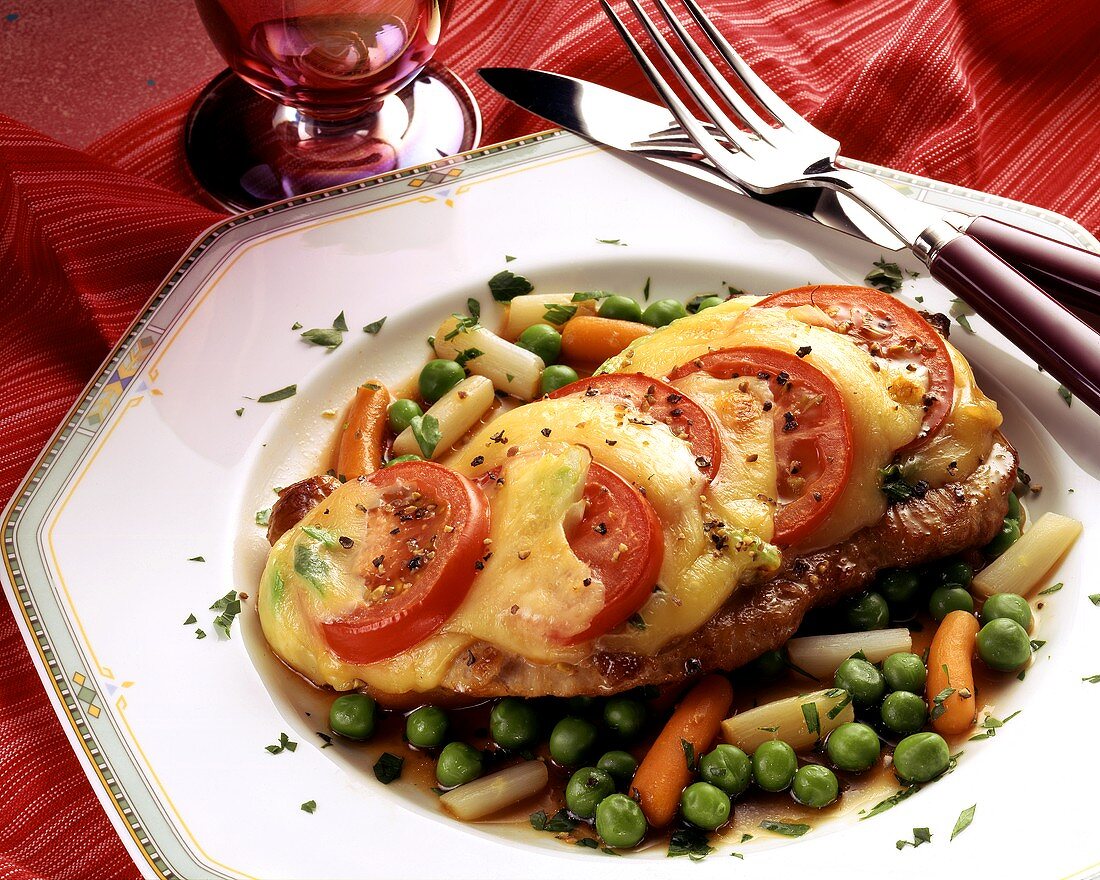 Pork escalope with tomatoes & toasted cheese on vegetables